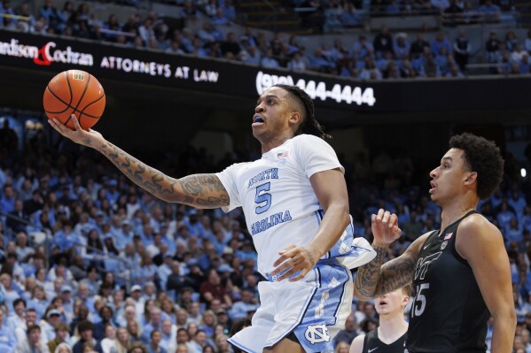 North Carolina's Armando Bacot (5) attempts a shot ahead of Virginia Tech's Lynn Kidd (15) during the first half of an NCAA college basketball game in Chapel Hill, N.C., Saturday, Feb. 17, 2024. (AP Photo/Ben McKeown)