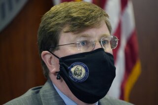 Mississippi Gov. Tate Reeves wears a face mask as he listens to Mississippi State Health Officer Dr. Thomas Dobbs, unseen, answer a question during the governor's COVID-19 briefing for reporters in Jackson, Miss., Monday, Jan. 4, 2021. (AP Photo/Rogelio V. Solis)