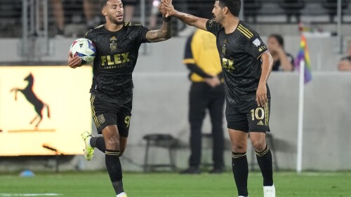 Los Angeles FC forward Denis Bouanga (99) celebrates with forward Carlos Vela (10) after scoring during the first half of an MLS soccer match against the Vancouver Whitecaps in Los Angeles, Saturday, June 24, 2023. (AP Photo/Ashley Landis)