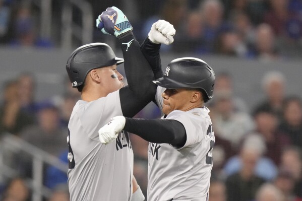 New York Yankees' Juan Soto, right, celebrates with teammate Aaron Judge after hitting a solo home run during the ninth inning of a baseball game against the Toronto Blue Jays in Toronto, Wednesday, April 17 2024. (Chris Young/The Canadian Press via AP)