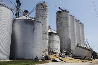 The scene of a grain silo collapse Tuesday, June 21, 2022, at the Yarmouth Elevator in Yarmouth, Iowa.  Crews continued to search Wednesday for a man missing beneath piles of grain and debris from a collapsed grain silo in southeastern Iowa.   (John Lovretta /The Hawk Eye via AP)