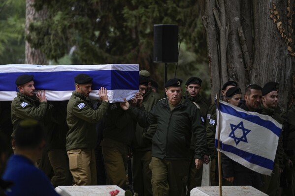 Israeli soldiers carry the flag-draped casket of reservist Hadar Kapeluk during his funeral at Mt. Herzl military cemetery in Jerusalem, Tuesday, Jan. 23, 2024. Kapeluk, 23, was killed during Israel's ground operation in the Gaza Strip, where the Israeli army has been battling Palestinian militants in the war ignited by Hamas' Oct. 7 attack into Israel. (AP Photo/Ohad Zwigenberg)