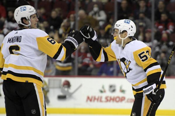 Pittsburgh Penguins center Teddy Blueger (53) celebrates his goal with defenseman John Marino (6) during the first period of an NHL hockey game against the New Jersey Devils, Sunday, Dec.  19, 2021, in Newark, N.J. (AP Photo/Bill Kostroun)