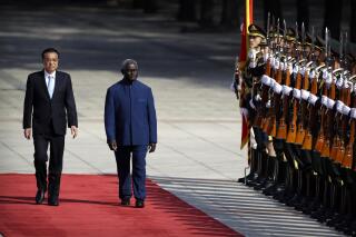 FILE - Chinese Premier Li Keqiang, left, and Solomon Islands Prime Minister Manasseh Sogavare review an honor guard during a welcome ceremony at the Great Hall of the People in Beijing, Wednesday, Oct. 9, 2019. Sogavare confirmed Wednesday, April 20, 2022, that his government had signed a new security agreement with China, but assured lawmakers it would not “undermine the peace and harmony of our region” as has been feared by the opposition and countries including the United States and Australia. (AP Photo/Mark Schiefelbein, File)