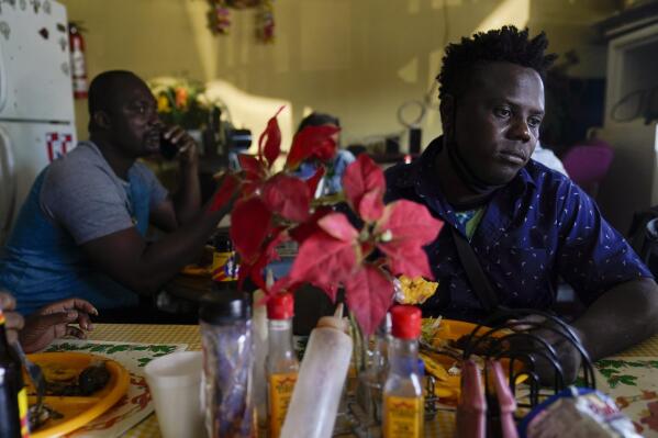 Robins Exile, of Haiti, eats at a Haitian restaurant, Monday, Sept. 20, 2021, in Tijuana, Mexico. Exile arrived to Tijuana the day before after changing his plans to head to the Texas border where thousands of Haitians have converged in recent days and now face deportation. He said messages on WhatsApp and Facebook from fellow Haitian migrants and their videos on YouTube warned him to steer clear of Ciudad Acuna, Mexico, across from Del Rio, Texas, and said it no longer is the easy place to cross into the U.S. that it was just a few weeks ago. (AP Photo/Gregory Bull)