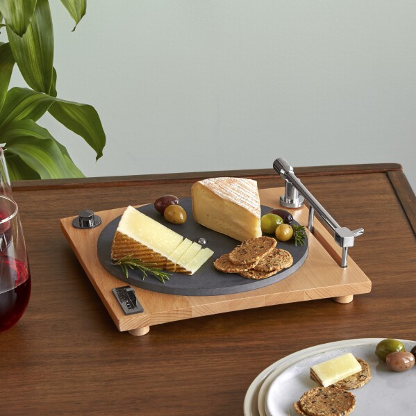 This image released by Uncommon Goods shows a cheese board designed to look like the most expensive, slick turntable, featuring a slate platter and hidden slicer in the one arm. (Uncommon Goods via AP)