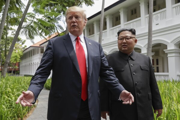 
              U.S. President Donald Trump and North Korea leader Kim Jong Un stop to talk with the media as they walk from their lunch at the Capella resort on Sentosa Island Tuesday, June 12, 2018 in Singapore. (AP Photo/Evan Vucci)
            