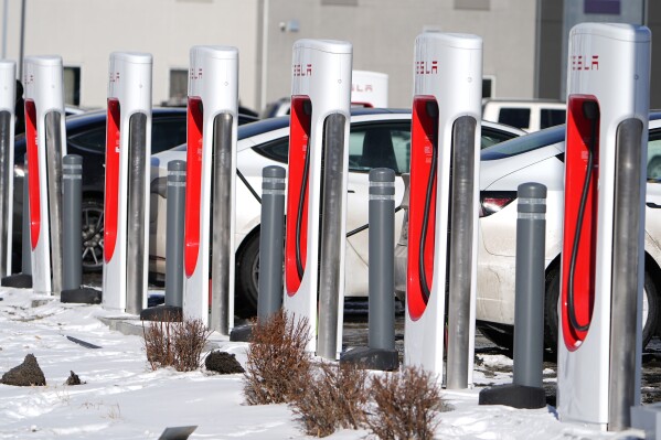 FILE - Motorists recharge their Tesla vehicles at a Tesla supercharging location, Jan. 16, 2024, in northeast Denver. Wisconsin Gov. Tony Evers signed bipartisan bills Wednesday, March 20, 2024 designed to jump-start creation of an electric vehicle charging network along Wisconsin's interstate system and major highways. (AP Photo/David Zalubowski, file)