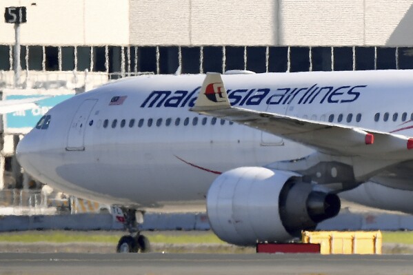 A Malaysia Airlines plane is parked at Sydney International Airport, in Sydney, Tuesday, Aug. 15, 2023. A 45-year-old man was charged on Tuesday with allegedly threatening to blow up a plane during a flight from Australia to Malaysia that returned Sydney.(Bianca De Marchi/AAP Image via AP)