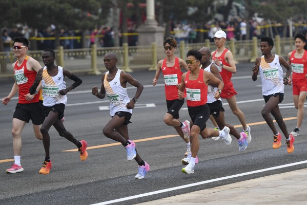 FILE - In this photo released by Xinhua News Agency, He Jie, the men's marathon record holder in China, wearing number 1, runs alongside African competitors during the Bejjing Half-Marathon 2024 in Beijing on April 14, 2024. Organizers are investigating the half-marathon race in Beijing after video from the race showing three African runners appearing to let the Chinese runner ahead of them right as they are about to cross the finish line sparked public speculation that the race was rigged. (Ju Huanzong/Xinhua via AP, File)