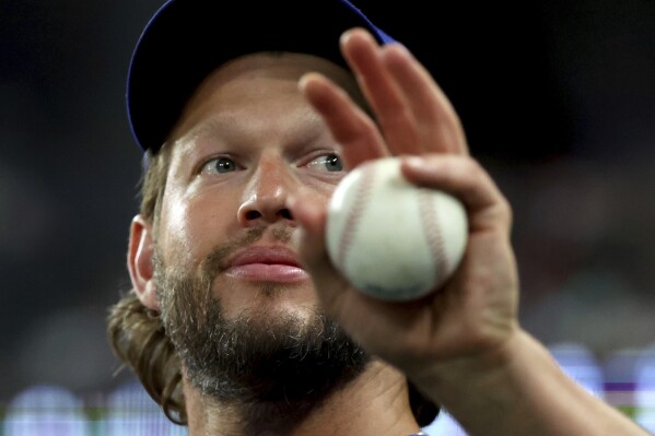 Los Angeles Dodgers pitcher Clayton Kershaw waves at fans from the dugout during a baseball game against the Texas Rangers, Friday, July 21, 2023, in Arlington, Texas. (AP Photo/Richard W. Rodriguez)