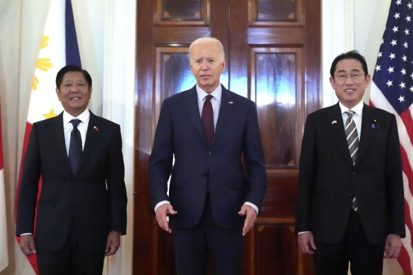 President Joe Biden, center, Philippine President Ferdinand Marcos Jr., left, and Japanese Prime Minister Fumio Kishida pose before a trilateral meeting in the East Room of the White House in Washington, Thursday, April 11, 2024. (AP Photo/Mark Schiefelbein)