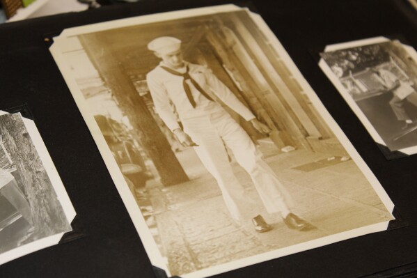A photo album in the home of Ira "Ike" Schab in Beaverton, Ore. on Monday, Nov. 20, 2023, shows an old photo of him in his U.S. Navy uniform during his first shore leave on Oahu, Hawaii, in December 1941 after the Pearl Harbor attacks. Schab is now 103 years old and plans to return to Pearl Harbor for the 82nd anniversary of the attack to remember the more than 2,300 servicemen killed. (APPhoto/Claire Rush)
