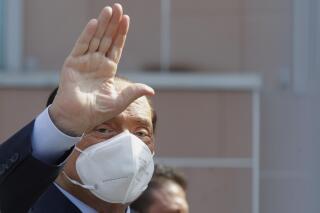 FILE - Silvio Berlusconi waves as he leaves the San Raffaele hospital in Milan, Italy, on Sept. 14, 2020. Former Italian Premier Silvio Berlusconi has been undergoing a series of medical examinations in a Milan hospital, a spokesman confirmed Sunday, Jan. 23, 2022, the day after the center-right political leader and media tycoon took his name out of contention to be Italy’s next president. Italian media reported that Berlusconi had been hospitalized at San Raffaele hospital, where is physician works, but the spokesman said he has been in and out of the hospital over recent days for a series of exams and a checkup. (AP Photo/Luca Bruno, File)