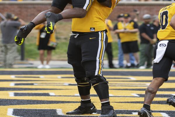 Missouri's Javon Foster, bottom, lifts teammate Missouri's Luther Burden III after Burden scored a touchdown during the first quarter of an NCAA college football game against Vanderbilt, Saturday, Oct. 22, 2022, in Columbia, Mo. (AP Photo/L.G. Patterson)