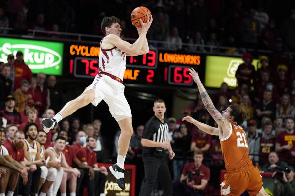 Iowa State guard Caleb Grill catches a pass over Texas guard Avery Benson (21) during the second half of an NCAA college basketball game, Saturday, Jan. 15, 2022, in Ames, Iowa. Iowa State won 79-70. (AP Photo/Charlie Neibergall)