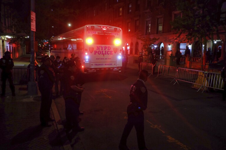 Un autobús policial que transporta a manifestantes arrestados en la Universidad de Columbia sale de la entrada del campus en la calle 114, el martes 30 de abril de 2024, en Nueva York.  Después de ingresar al campus, un grupo de policías se acercó a Hamilton Hall, el edificio administrativo que los estudiantes manifestantes habían comenzado a ocupar ese mismo día.  (Foto AP/Julius Modell)