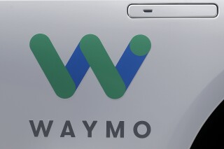 FILE - In this May 8, 2018, file photo, a Waymo logo is displayed on the door of a car at the Google I/O conference in Mountain View, Calif. Waymo is issuing a recall for the first time due to a software concern after two of its self-driving vehicles hit the same pickup truck that was being towed. (AP Photo/Jeff Chiu, File)