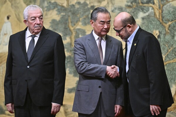 China's Foreign Minister Wang Yi, center, hosts an event for Mahmoud al-Aloul, left, vice chairman of Fatah, and Mussa Abu Marzuk, a senior member of Hamas, to meet at the Diaoyutai State Guesthouse in Beijing, Tuesday, July 23, 2024. (Pedro Pardo/Pool Photo via ĢӰԺ)