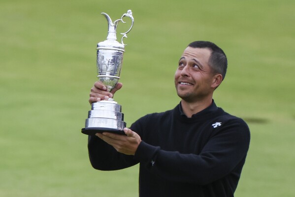 Xander Schauffele of the United States holds the Claret Jug trophy aloft after winning the British Open Golf Championships at Royal Troon golf club in Troon, Scotland, Sunday, July 21, 2024. (ĢӰԺ Photo/Scott Heppell)