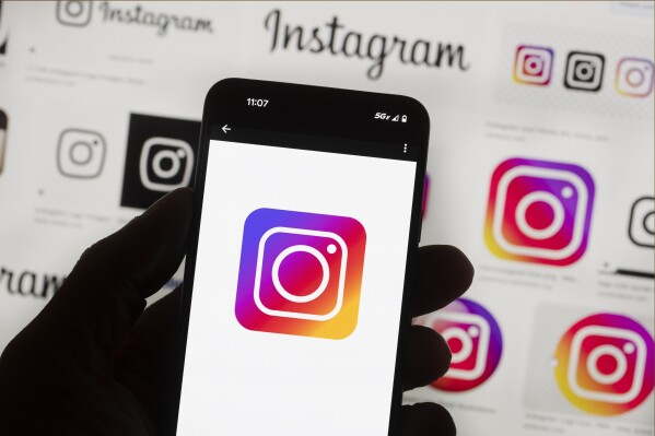 File - The Instagram logo is seen on a cell phone in Boston, USA, Oct. 14, 2022. The owner of Facebook and Instagram says it'll put labels on political ads created using artificial intelligence. The new policy announced Wednesday by Meta goes into effect Jan. 1 and will apply worldwide. (AP Photo/Michael Dwyer, File)