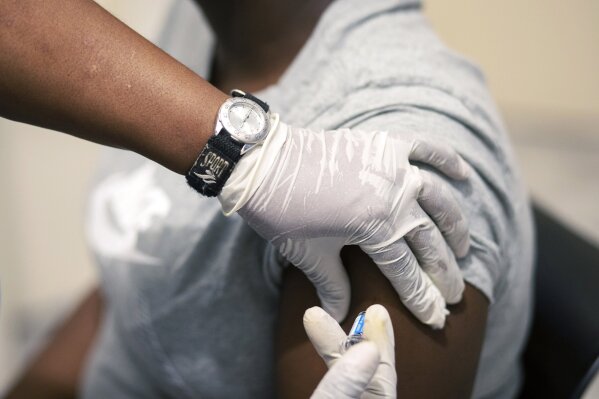 Sisi Ndebele, receives a seasonal influenza vaccine from a nurse at a local pharmacy clinic in Johannesburg, South Africa at 1800 on Friday, April 24, 2020. (AP Photo/Themba Hadebe)