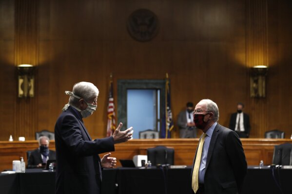 FILE - In this Thursday, May 7, 2020 file photo, National Institutes of Health Director Dr. Francis Collins, left, speaks with Chairman Sen. Lamar Alexander, R-Tenn., prior to a Senate Health Education Labor and Pensions Committee hearing on new coronavirus tests on Capitol Hill in Washington.  Collins has lauded the majority of American faith communities for treating the pandemic as an opportunity to live out their values by helping the vulnerable. He also offered careful criticism for the “occasional examples of churches who reject the scientific conclusions and demand the right to continue to assemble freely, even in the face of evidence that this endangers their whole community.”(AP Photo/Andrew Harnik, Pool)