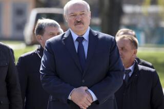FILE - In this Monday April 26, 2021 file photo, Belarus President Alexander Lukashenko, accompanied by officials, attends a requiem rally on the occasion of the 35th anniversary of the Chernobyl disaster in the town of Bragin, some 360 km (225 miles) south-east of Minsk, Belarus. Raman Pratasevich, a founder of a messaging app channel that has been a key information conduit for opponents of Belarus’ authoritarian president, has been arrested after an airliner in which he was riding was diverted to Belarus because of a bomb threat. The presidential press service said President Alexander Lukashenko personally ordered that a MiG-29 fighter jet accompany the Ryanair plane — traveling from Athens, Greece, to Vilnius, Lithuania — to the Minsk airport. (Sergei Sheleg/BelTA Pool Photo via AP, File)