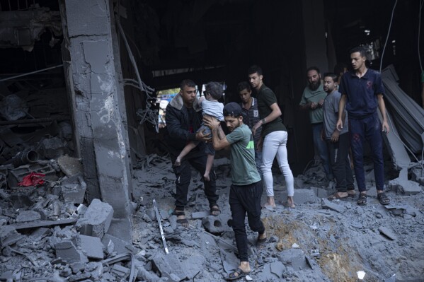 Palestinians evacuate wounded from a building destroyed in Israeli bombardment in Khan Younis, Gaza Strip, Thursday, Oct. 19, 2023. (AP Photo/Fatima Shbair)