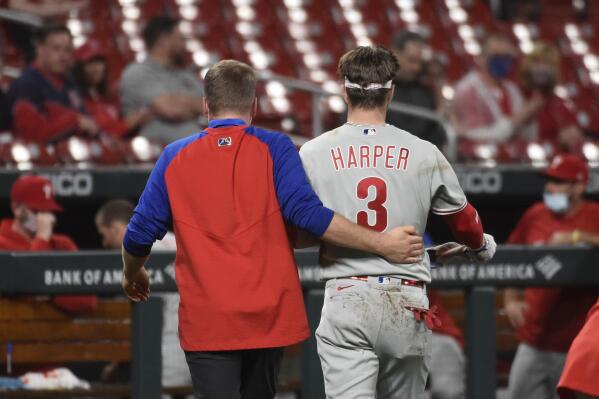 Philadelphia Phillies right fielder Bryce Harper, right, is helped off the field after getting hit by a pitch during the sixth inning of the team's baseball game against the St. Louis Cardinals on Wednesday, April 28, 2021, in St. Louis. (AP Photo/Joe Puetz)