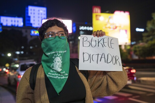 A member of a feminist group holds a sign that reads in Spanish: 