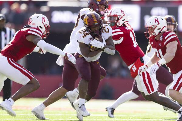 Minnesota's Mohamed Ibrahim, center, carries the ball as Nebraska's Myles Farmer, left, and Chris Kolarevic close in during the second half of an NCAA college football game Saturday, Nov. 5, 2022, in Lincoln, Neb. Ibrahim rushed for 128 yards and two touchdowns during Minnesota's 20-13 victory. (AP Photo/Rebecca S. Gratz)