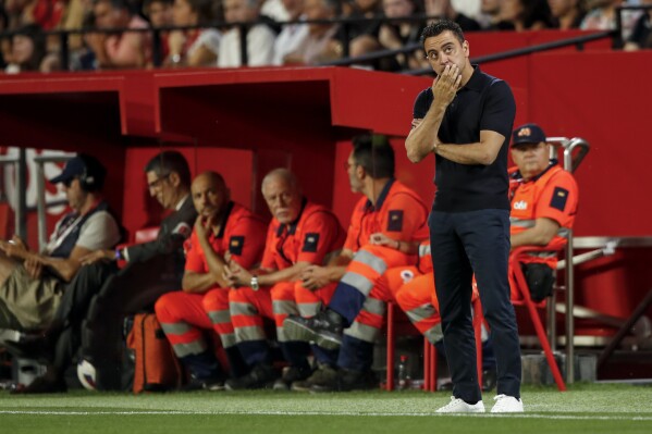 Barcelona's head coach Xavi Hernandez gestures during a Spanish La Liga soccer match between Sevilla and FC Barcelona at the Ramon Sanchez Pizjuan stadium in Seville, Spain, Sunday, May 26, 2024. (AP Photo/Fermin Rodriguez)