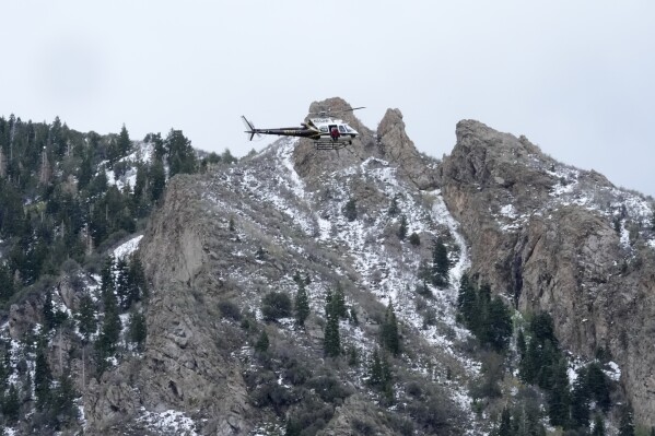 A Utah Department of Public Safety helicopter carries rescuers from Hidden Valley Park on Thursday, May 9, 2024, Thursday, May 9, 2024, in Sandy, Utah. One skier was rescued and two remained missing following an avalanche in the mountains outside of Salt Lake City. The slide happened after several days of spring snowstorms. (AP Photo/Rick Bowmer)