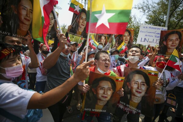 Myanmar nationals living in Thailand hold pictures of deposed Myanmar leader Aung San Suu Kyi as they protest against the military coup in front of the United Nations building in Bangkok, Thailand, Sunday, March 7, 2021. (AP Photo/Nava Sangthong)