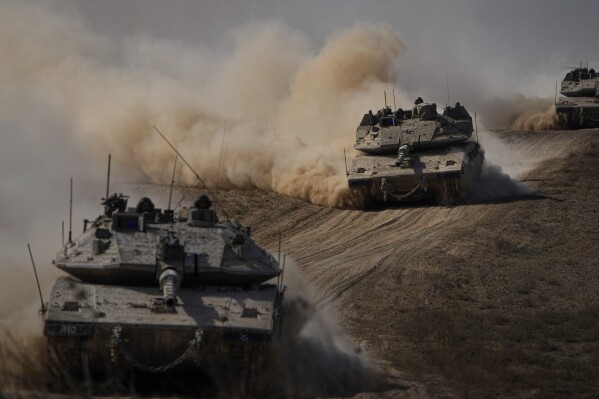 Israeli tanks head towards the Gaza Strip border in southern Israel on Friday, Oct.13, 2023. (AP Photo/Ariel Schalit)
