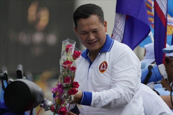 Hun Manet, a son of Cambodia Prime Minister Hun Sen, receives flowers from his supporters as he leads a procession to mark the end of an election campaign of Cambodian People's Party, in Phnom Penh, Cambodia, on July 21, 2023. Cambodian King Norodom Sihamoni on Monday, Aug. 7, formally endorsed army chief Hun Manet to succeed his father and long-ruling Prime Minister Hun Sen as the nation's leader later this month after their party sealed victory in a one-sided election last month. (AP Photo/Heng Sinith)