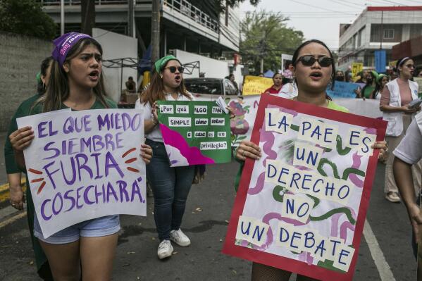 Youths carry pro-abortion and anti-violence messages during a march on International Women's Day in San Pedro Sula, Honduras, Wednesday, March 8, 2023. The signs read in Spanish: "He who plants fear, will sow furry," left, "PAE is a right not a debate, right, referring to the emergency contraceptive pill, and "Why is something as simple as returning home is a privilege?" (AP Photo/Ginnette Riquelme)