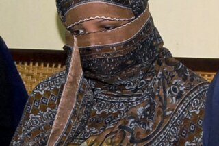 FILE - In this Nov. 20, 2010, file photo, Aasia Bibi, a Pakistani Christian woman, listens to officials at a prison in Sheikhupura near Lahore, Pakistan. Pakistani media say Aasia Bibi, a Christian woman acquitted of blasphemy after spending eight years on death row, has left Pakistan for Canada to be reunited with her daughters. Wilson Chawdhry of the British Pakistani Christian Association told The Associated Press on Wednesday, May 8, 2019, he received a telephone text message from a British diplomat stating simply that “Aasia is out.” (AP Photo, File)
