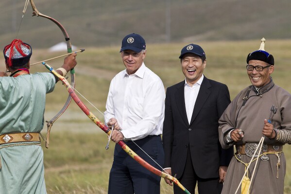 FILE - U.S. Vice President Joe Biden, center left, accompanied by Mongolian Prime Minister Sukhbaatar Batbold, center right, tries out archery during a tour in Ulan Bator, Mongolia, Aug. 22, 2011. The release of a transcript of Biden's interview with prosecutors investigating his handling of classified documents offers a rare window into the day-to-day life for the president. One question morphed into a well-worn tale of that one time he "embarrassed the hell" out of the leader of Mongolia. (AP Photo/Andy Wong, File)