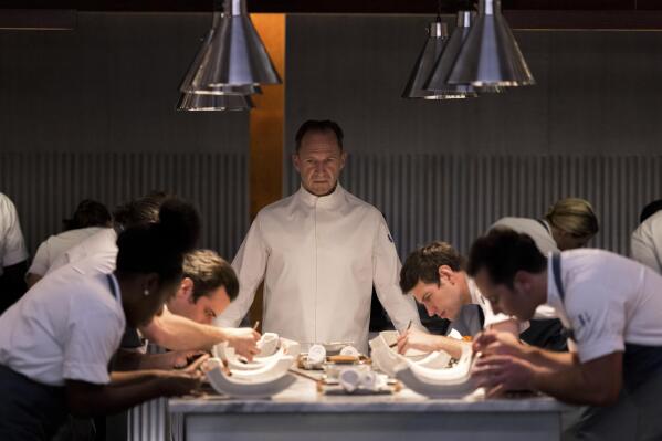 This image released by Searchlight Pictures shows Ralph Fiennes, center, in a scene from the film "The Menu." (Eric Zachanowich/Searchlight Pictures via AP)