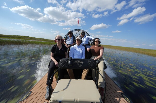Miccosukee Tribal elder Michael Frank, top left, rides an airboat with members of a task force that brings together federal, state, tribal and local agencies working to restore and protect the Florida Everglades, on a field visit to the Miccosukee Indian Reservation ahead of a task force meeting hosted by the tribe, Wednesday, April 24, 2024 on the Fla. (AP Photo/Rebecca Blackwell)