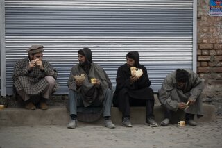 Kashmiri men drink tea on a cold day at a local market in Srinagar, Indian controlled Kashmir, Friday, Nov. 20, 2020. (AP Photo/Mukhtar Khan)