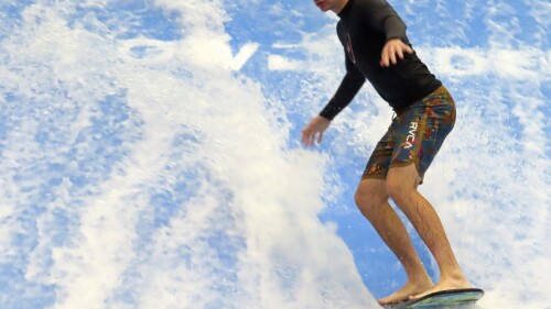 A man rides a surfboard on a surfing simulator during a preview of the Island Waterpark in Atlantic City, N.J., Thursday, June 22, 2023. The $100 million park, which will open June 30, is part of an effort by Atlantic City to offer guests — particularly those with children — something to do other than gambling. It's a strategy Las Vegas has been using to great effect. (AP Photo/Wayne Parry)