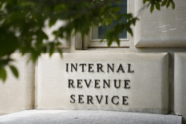 FILE - Un cartello all'esterno dell'edificio dell'Internal Revenue Service a Washington, il 4 maggio 2021. Con effetto immediato, l'Internal Revenue Service metterà fine alla sua politica decennale di effettuare visite a domicilio e di lavoro senza preavviso, in un cenno alla sicurezza dei lavoratori e alla lotta ai truffatori che si spacciano per agenti dell'IRS.  (Foto AP/Patrick Semansky, file)