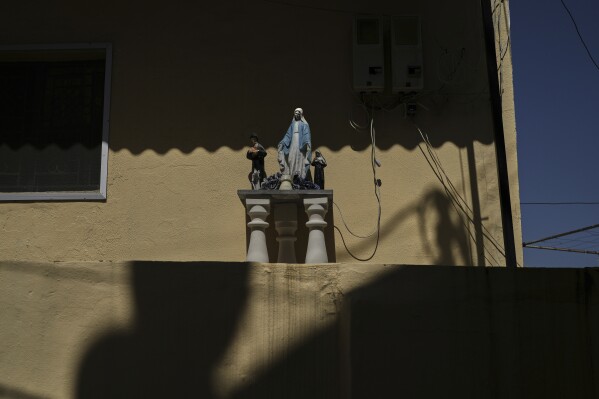 A statue of the Virgin Mary is surrounded by shadows during a Good Friday display outside a home in Quraye, near the southern port city of Sidon, Lebanon, Thursday, April 17, 2025. (AP Photo/Hassan Ammar)