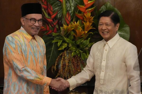Philippine President Ferdinand Marcos Jr., right, shakes hands with Malaysia's Prime Minister Anwar Ibrahim after delivering their statements to the press at the Malacanang presidential palace in Manila, Philippines on Wednesday Mar. 1, 2023. (AP Photo/Aaron Favila, Pool)