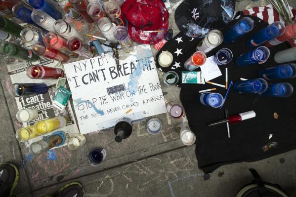 FILE - In this Saturday, July 19, 2014, file photo, a memorial for Eric Garner rests on the pavement near the site of his death,  in the Staten Island borough of New York. In 2014, the world witnessed a New York police officer put Garner in a chokehold while arresting him for allegedly selling illegal cigarettes in Staten Island. The video, which would go on to set precedence for the documentation of police brutality, highlighted the use of a chokehold by the police department, which had banned the method in November 1993. But unlike in the aftermath of George Floyd's killing in 2020, little to no legislative change was spurred from Garner's death. (AP Photo/John Minchillo, File)