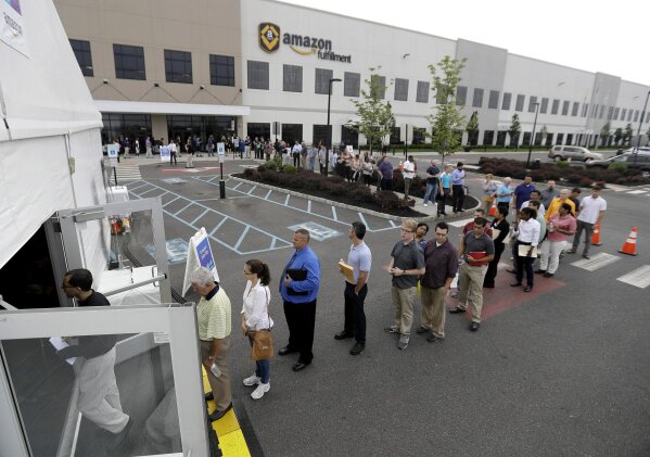 
              Job candidates stand in line outside of a processing tent outside the Amazon fulfillment center in Robbinsville, N.J., during a job fair, Wednesday, Aug. 2, 2017. Amazon plans to make thousands of job offers on the spot at nearly a dozen U.S. warehouses. (AP Photo/Julio Cortez)
            