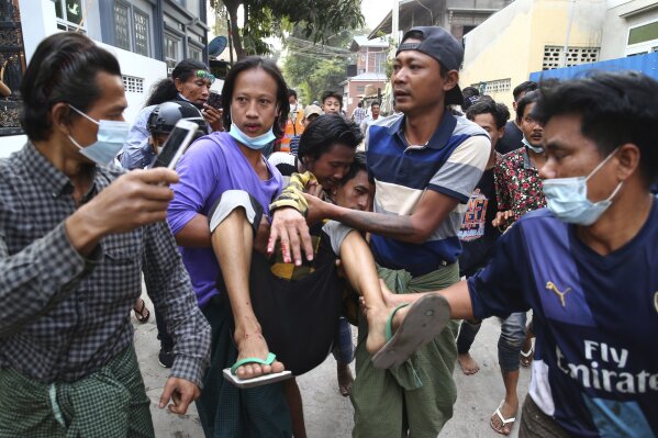 A man is carried after police dispersed protesters in Mandalay, Myanmar on Saturday, Feb. 20, 2021. Security forces in Myanmar ratcheted up their pressure against anti-coup protesters Saturday, using water cannons, tear gas, slingshots and rubber bullets against demonstrators and striking dock workers in Mandalay, the nation's second-largest city. (AP Photos)